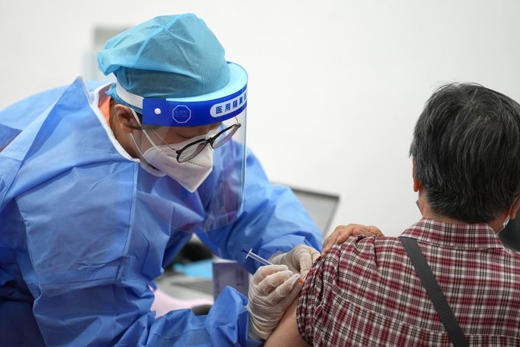 A medical worker injects a booster shot of COVID-19 vaccine for a resident at Aoyuncun Subdistrict in Chaoyang District, Beijing, capital of China, July 13, 2022. (Xinhua/Ju Huanzong)