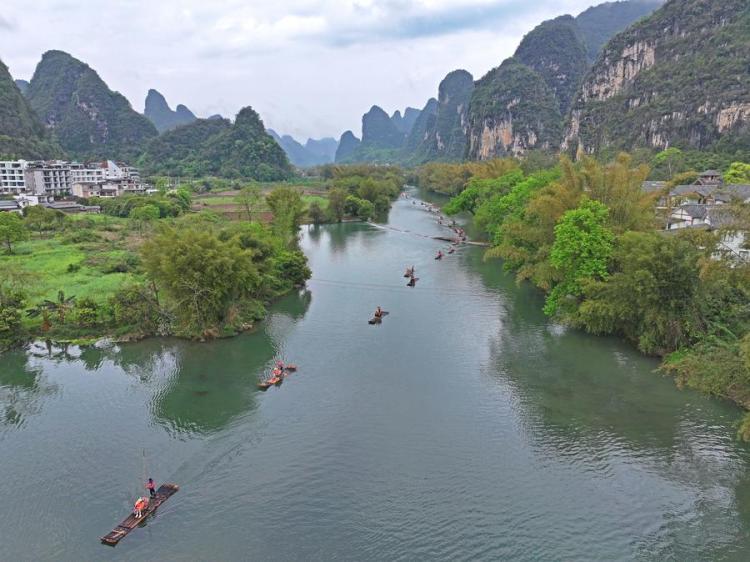 An aerial drone photo taken on March 29, 2024 shows tourists taking bamboo rafts on the Yulong River in Yangshuo County, Guilin City, south China's Guangxi Zhuang Autonomous Region. (Xinhua/Zhou Hua)