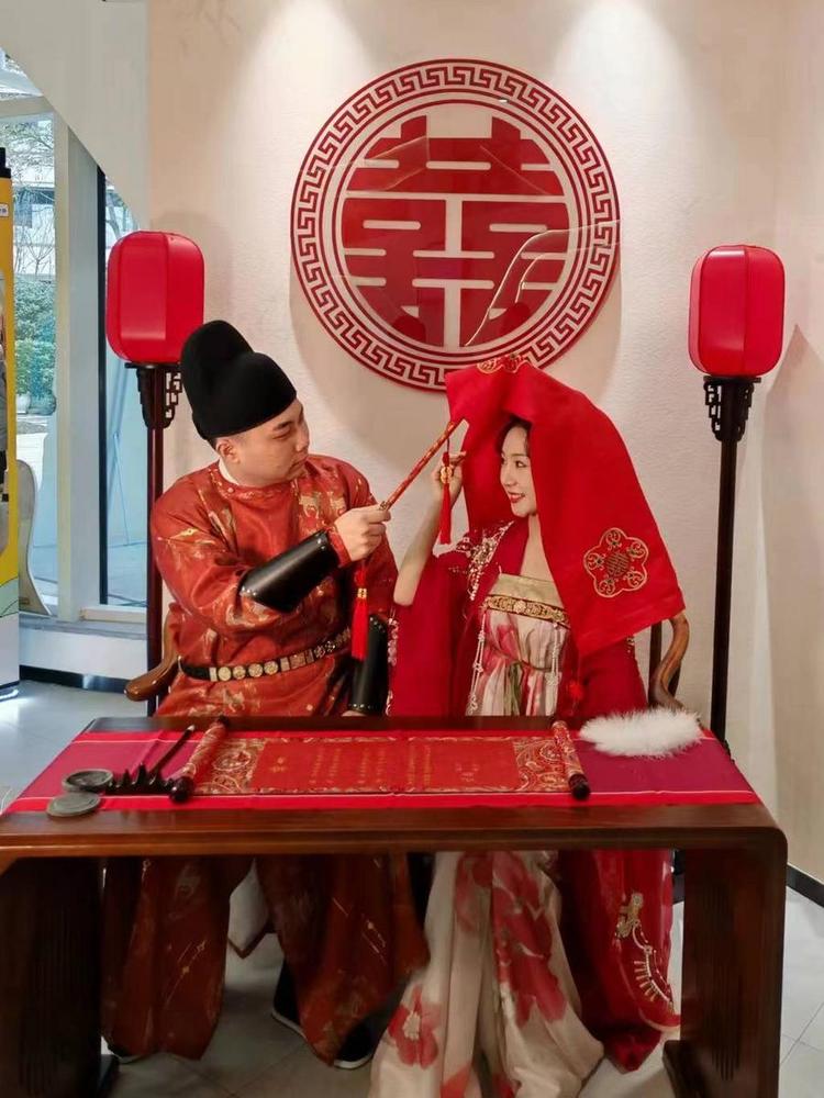 This photo taken on Dec. 12, 2023 shows a couple wearing traditional Chinese ceremonial attires at a marriage registration office in the Liangjiang New Area in southwest China's Chongqing Municipality. (Xinhua)