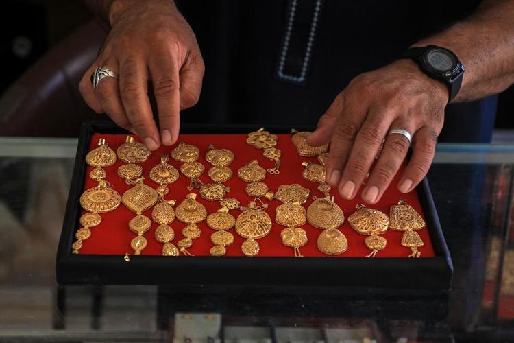 A merchant displays gold crafts at a gold shop in Khan Younis, southern Gaza, on June 26, 2024. (Photo by Rizek Abdeljawad/Xinhua)