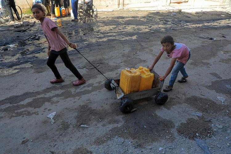 Children leave after fetching water in the southern Gaza Strip city of Khan Younis, on July 2, 2024. (Photo by Rizek Abdeljawad/Xinhua)