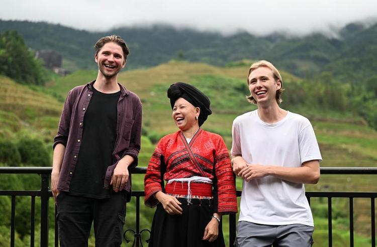 Pan Fenglan (C) talks with German tourists at her homestay at Dazhai Village of Longsheng County, south China