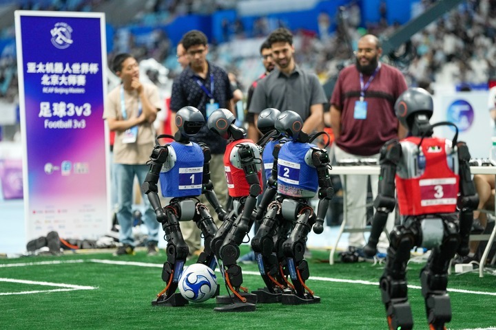 Humanoid robots compete during a 3V3 soccer match at the 2025 World Humanoid Robot Games in Beijing, capital of China, Aug. 15, 2025. (Xinhua/Ju Huanzong)