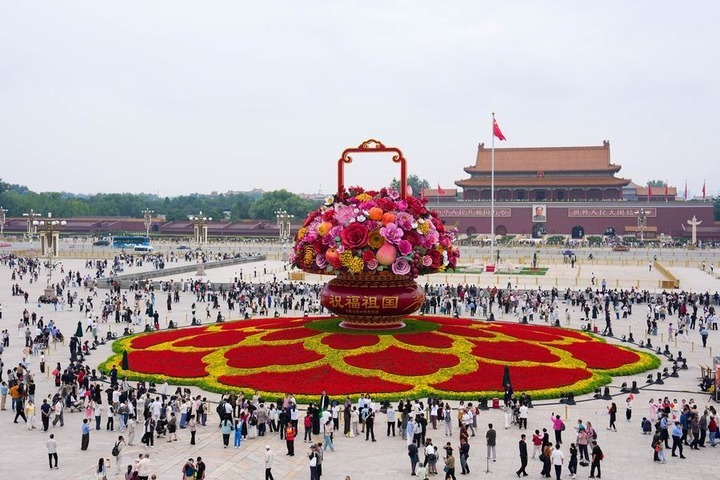 Tourists view a giant floral basket installation at Tian'anmen Square in Beijing, capital of China, Sept. 25, 2026. (Xinhua/Ju Huanzong)