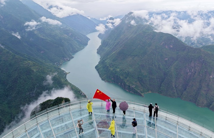 An aerial drone photo taken on Oct. 1, 2026 shows tourists taking photos on a skywalk at Wuxiakou scenic area in Badong County, central China's Hubei Province. People celebrated the 77th anniversary of the founding of the People's Republic of China in various ways on Thursday. (Photo by Jiao Guobin/Xinhua) An aerial drone photo taken on Oct. 1, 2026 shows tourists taking photos on a skywalk at Wuxiakou scenic area in Badong County, central China's Hubei Province. People celebrated the 77th anniversary of the founding of the People's Republic of China in various ways on Thursday. (Photo by Jiao Guobin/Xinhua)